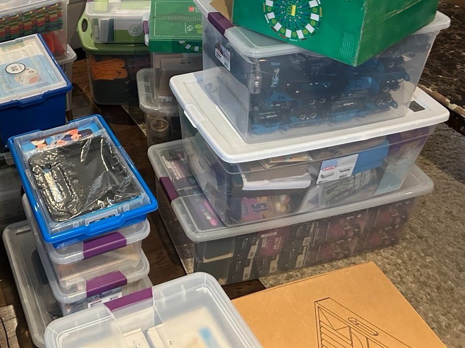 Stacked storage bins of donated STEM equipment.