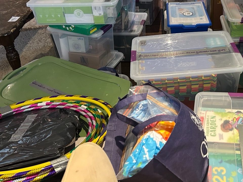 Donated activity materials, including foam mats and hoops, in bins.