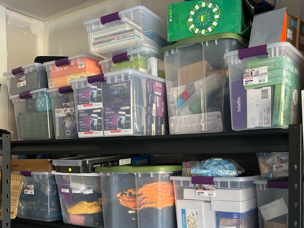 Shelves of labelled bins holding donated STEM kits and learning resources.